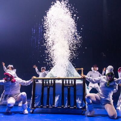 Six elfes espiègles vêtus de vêtements blancs dansent autour d'un lit - Twas The Night Before Christmas Cirque du Soleil spectacle Noël